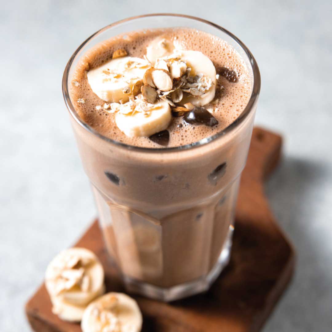 En nyttig milkshake med smak av choklad med skivad banan ovanpå.